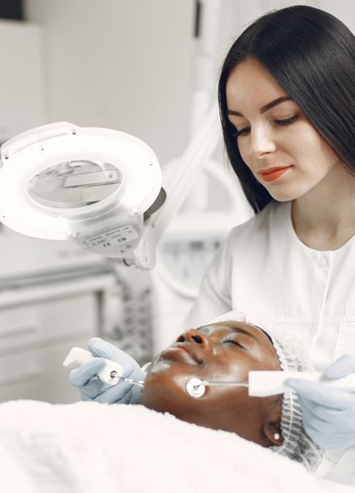 A skin-care specialist examining a patient's face